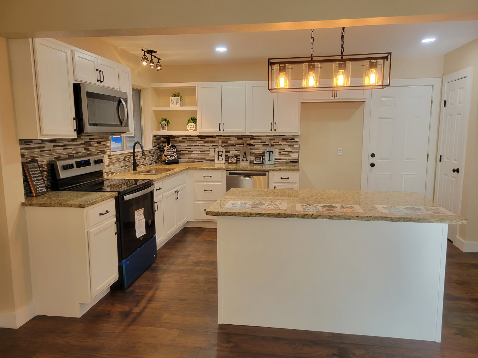 Remodeled kitchen with center island, granite counters and new lighting