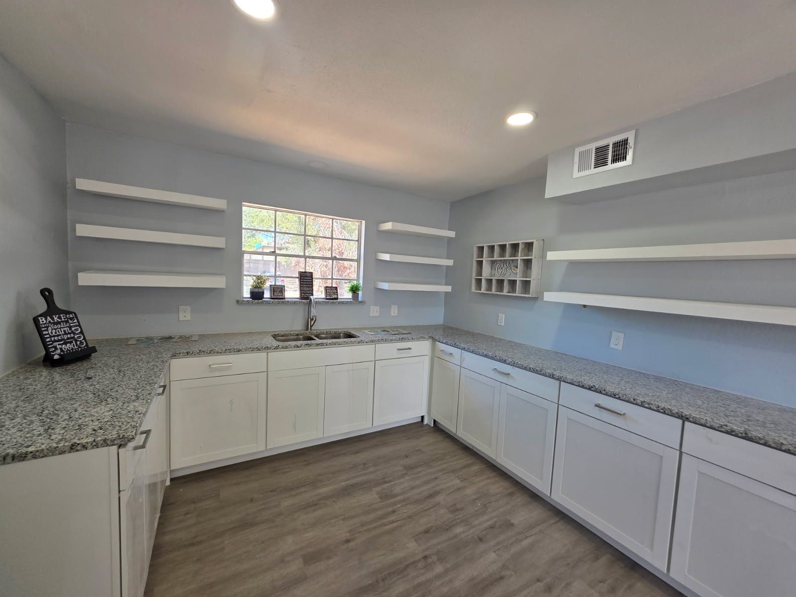 Remodeled kitchen with white shaker cabinets, granite counters and custom open shelving